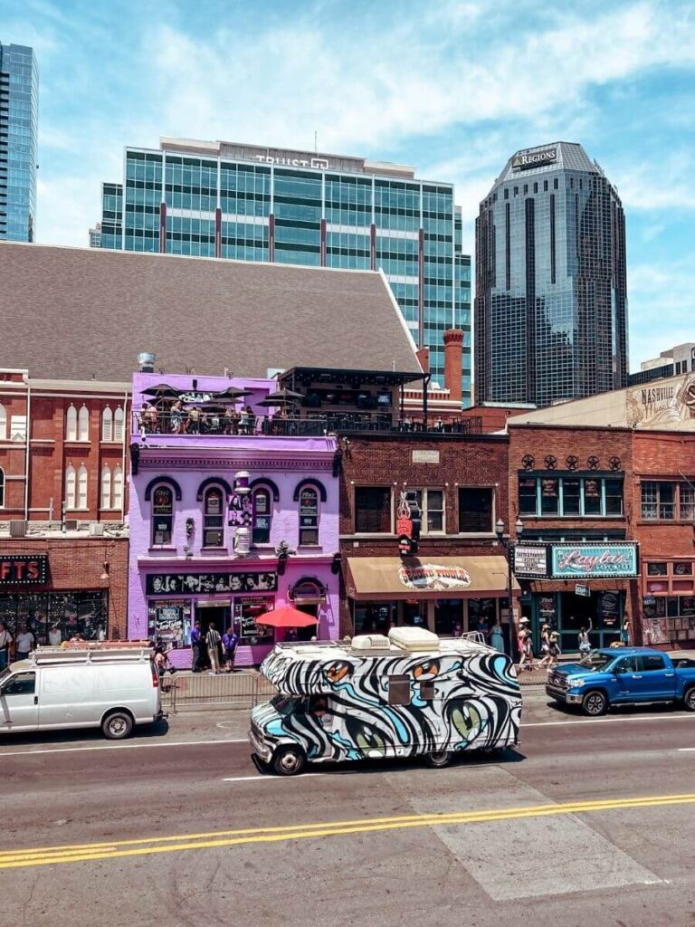 Busy daytime view of Music Row in Nashville, lined with honky-tonk bars and music shops.