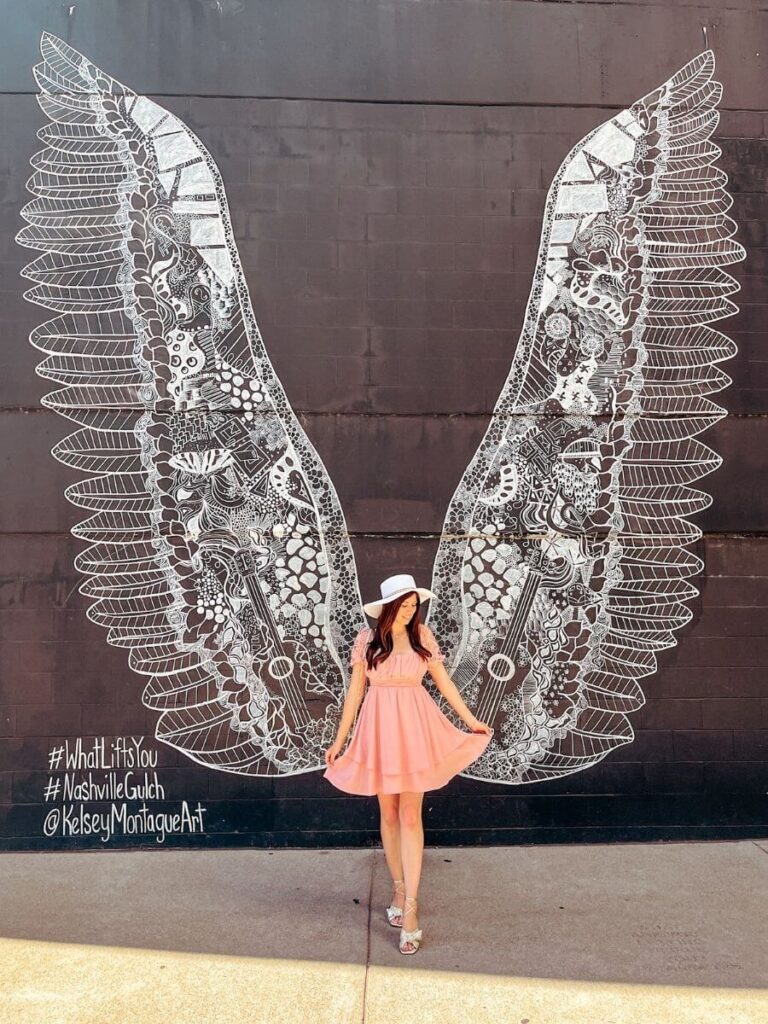 Posing in front of the WhatLiftsYou Wings mural – a must-see Nashville Instagram spot