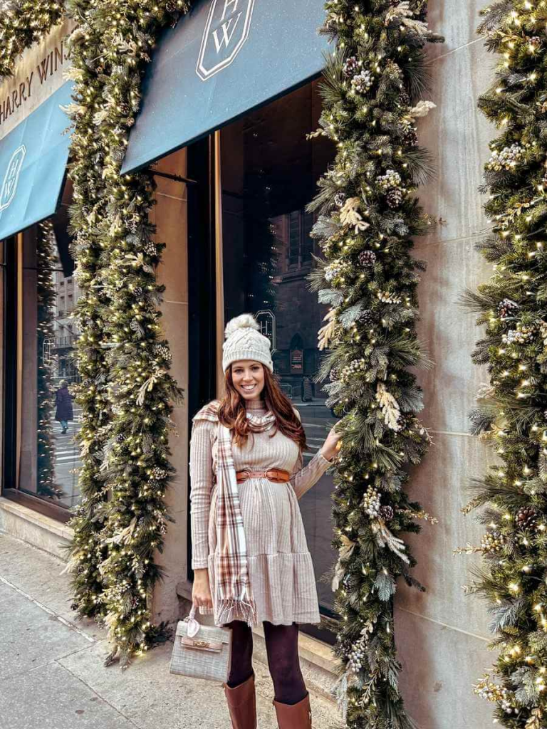 Styling a sweater dress with a belt, scarf and tonal boots to create a put together outfit.