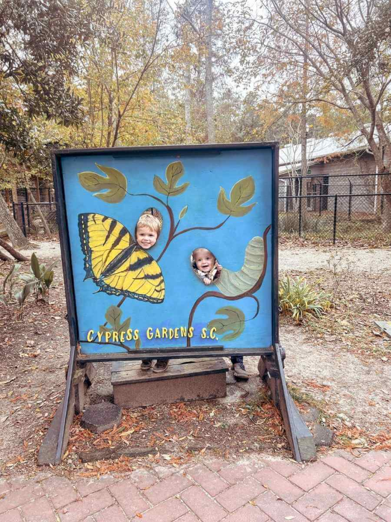 Posing by the butterfly house at Cypress Gardens, a fun place to add to your family vacation to Charleston itinerary.