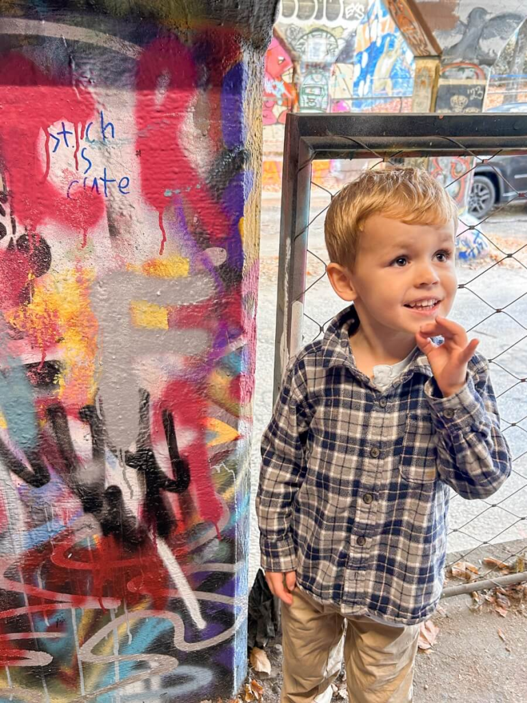 Child drawing graffiti on the walls of Krog Street Tunnel in Atlanta. A cool cheap thing to do in Atlanta with kids.