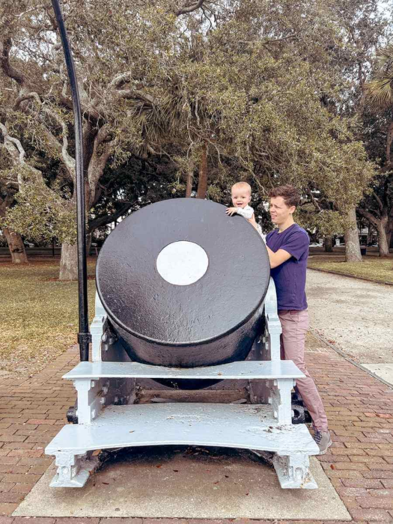 Father and his baby playing with a pretend cannon at White Point Park in Charleston