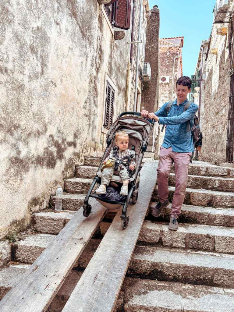 Parent navigating steep Old Town steps during a day in Dubrovnik with a stroller — a challenge when visiting with toddlers.