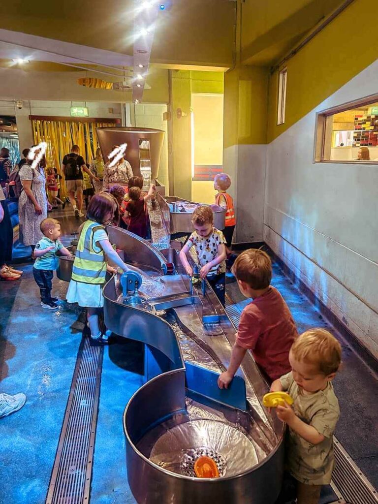 Water play table in The Garden exhibit at the Science Museum London, designed for hands-on toddler exploration.
