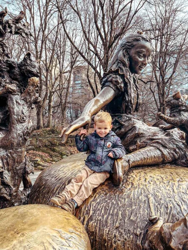 My son climbing the Alice in Wonderland statue in Central Park — a family highlight of our 4 days in New York with kids itinerary