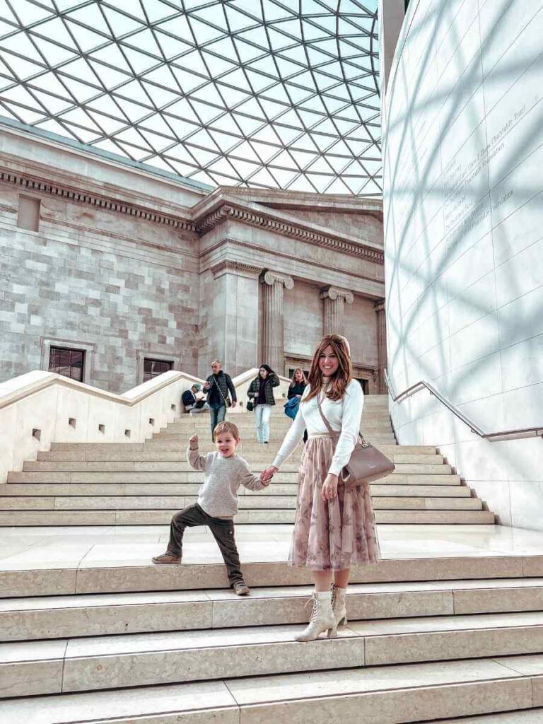 Mum in the City and her son standing on the grand steps inside the British Museum London