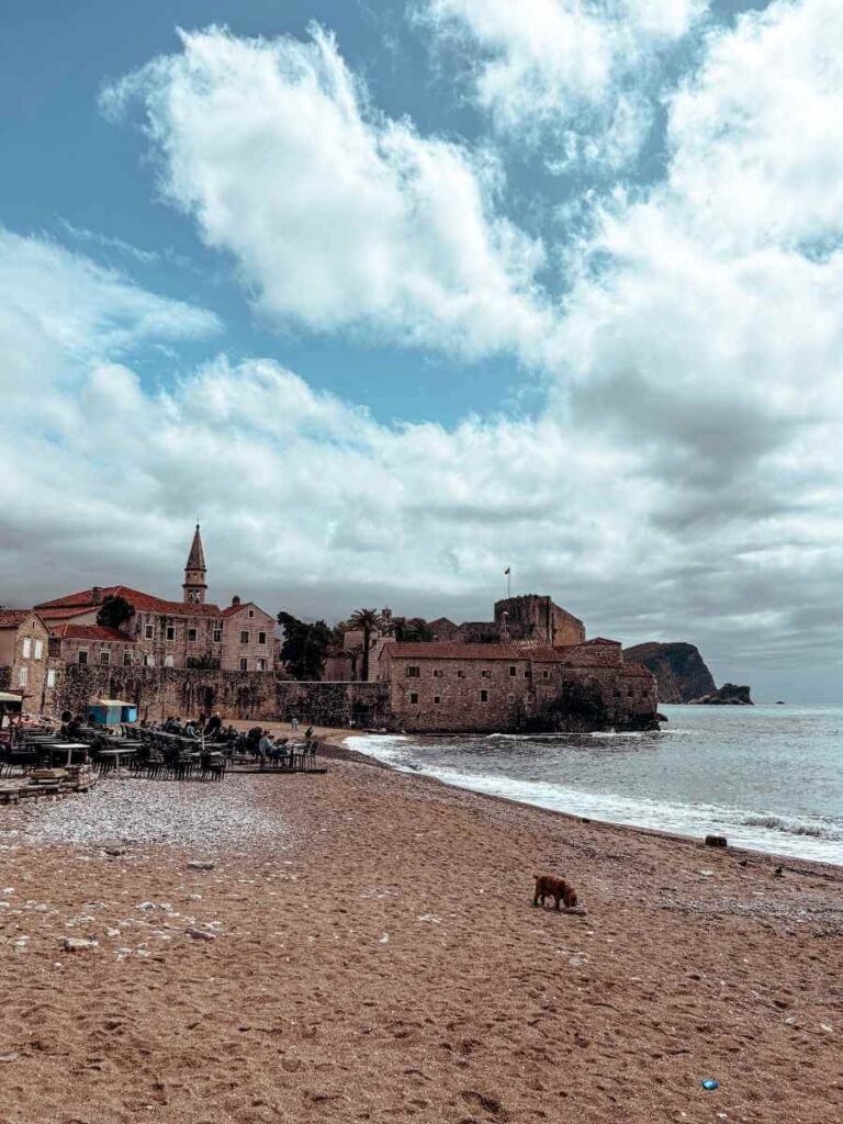 abeach in Budva with sun loungers and a view of the turquoise sea
