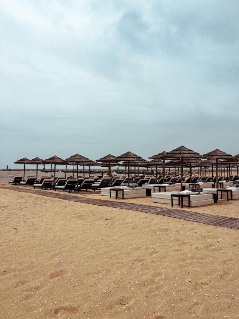 Sunbeds and parasols lined up on Vilamoura Beach, ideal for a relaxing day by the sea with kids