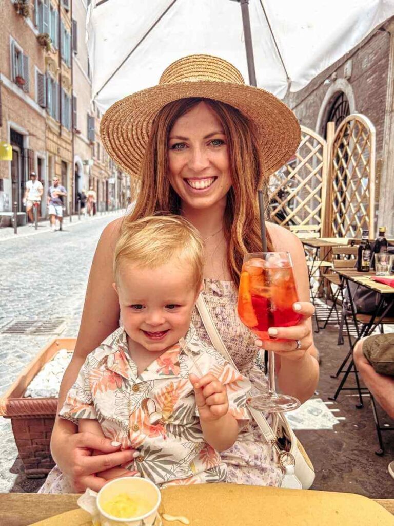 Mum enjoying an Aperol Spritz while her son eats gelato at a Roman café during 3 days in Rome Italy