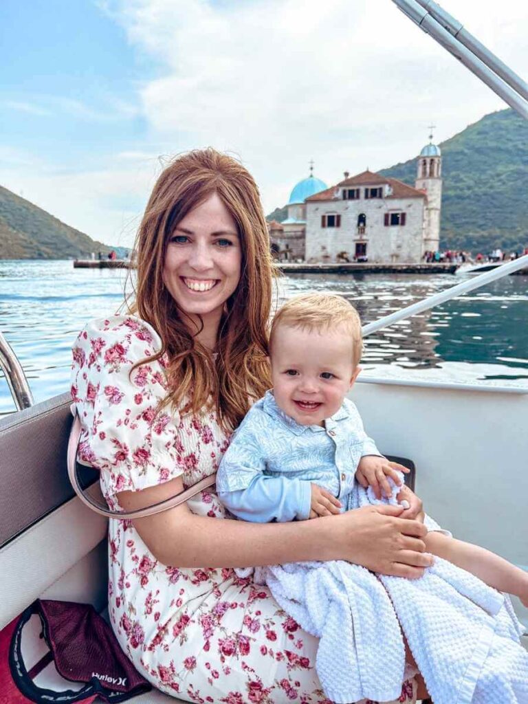 Mother holding baby during a scenic boat tour in Kotor Bay, Montenegro.