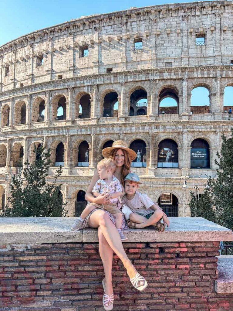 Family posing in front of the Colosseum in Rome on a sunny day, one of the most Instagrammable spots in the city.