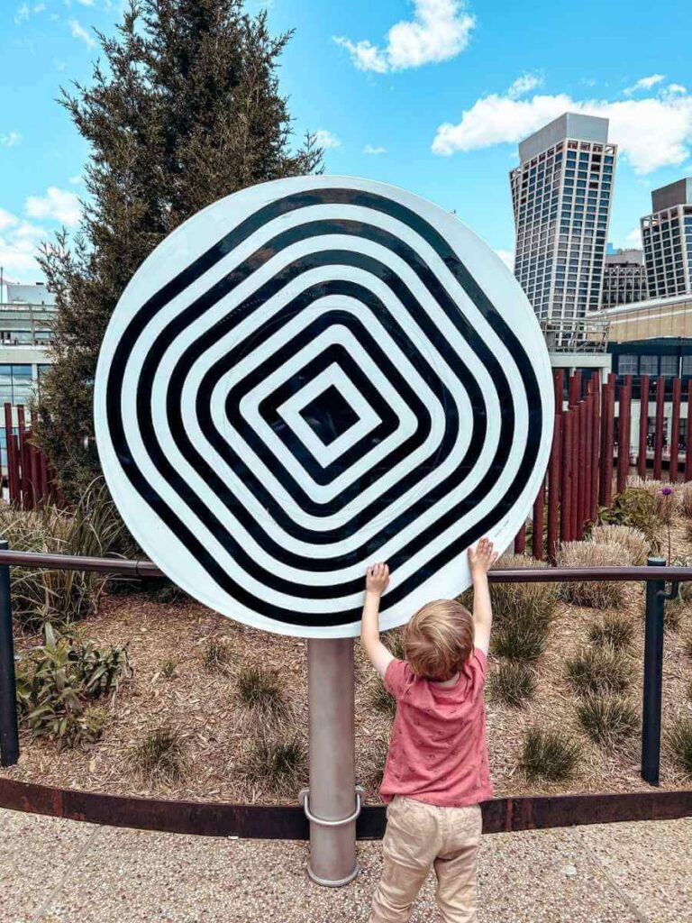 My son playing with a spinning sculpture at Little Island — a playful stop during our 4-day NYC trip with kids