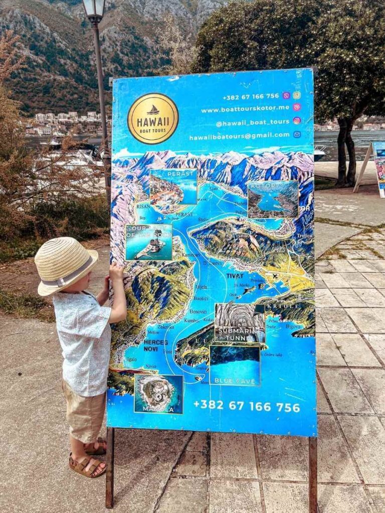 Child studying the boat tour route map before a family-friendly trip in Kotor