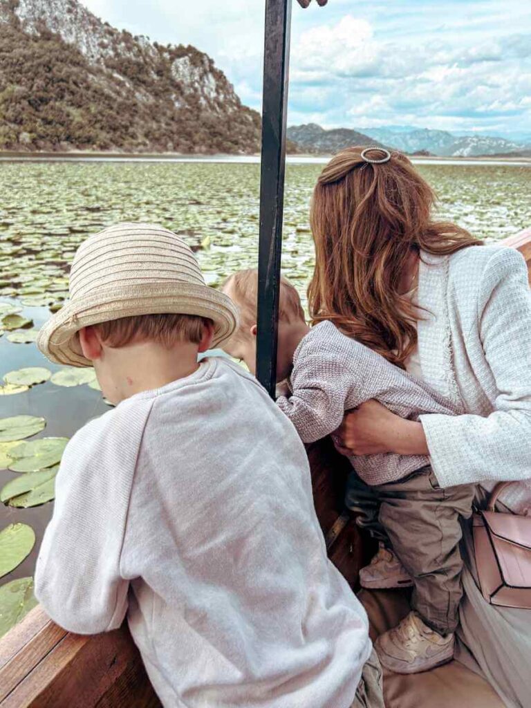 Mother and children looking lily pads on Lake Skadar during a family-friendly boat trip