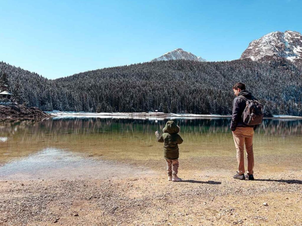 Father and young son admiring the view of Black Lake (Crno Jezero) in Durmitor National Park, Montenegro