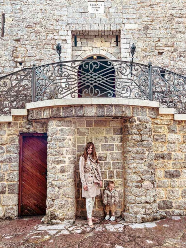 Mum in the City and her toddler standing outside the historic Budva Citadel fortress in Montenegro
