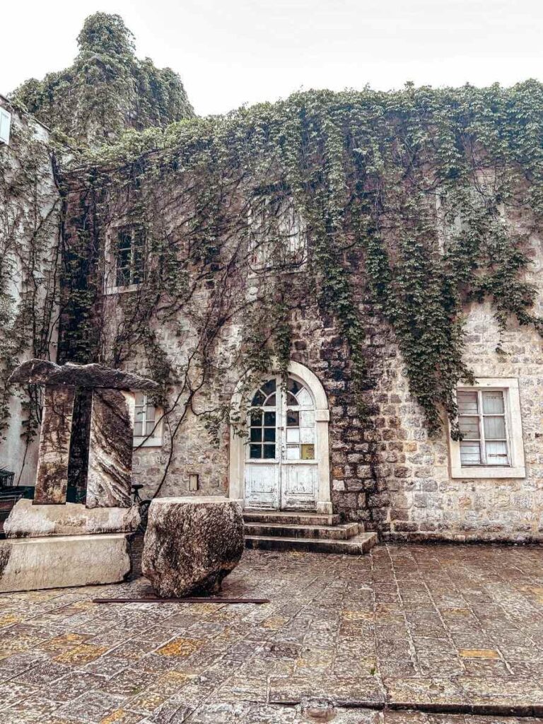 Charming stone buildings in Budva Old Town with shutters and flowers
