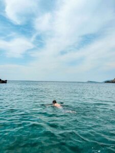 My husband swimming in the crystal-clear water near the Blue Cave in Montenegro