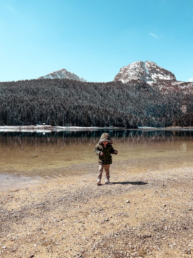 Young boy standing near the edge of Black Lake in Durmitor National Park
