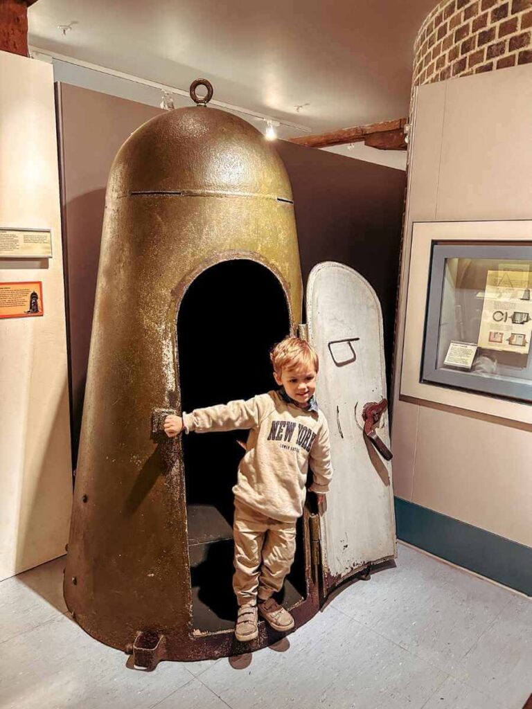 Child posing beside a historical war missile at the Museum of London Docklands