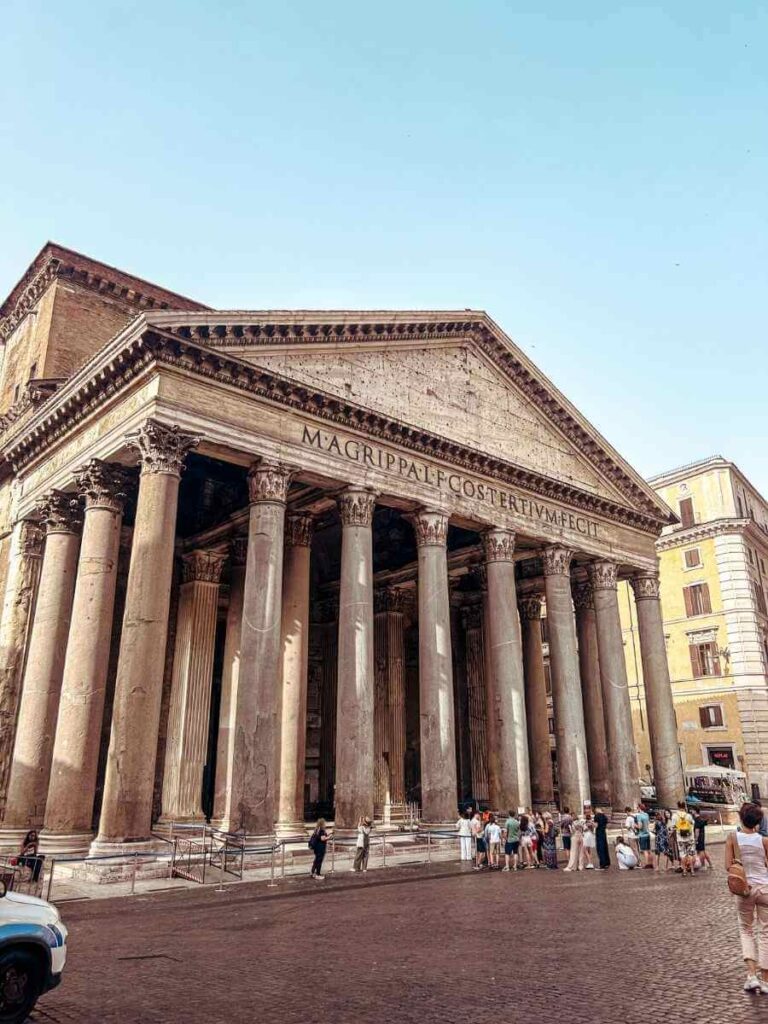 Exterior of the Pantheon in Rome with tall columns and bustling square