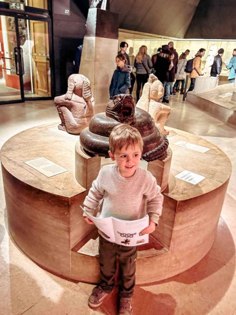 Young boy holding a British Museum kids’ activity booklet during a visit
