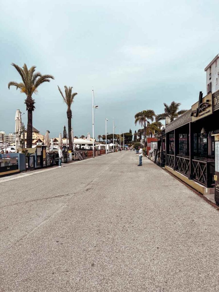 View of Vilamoura Marina with boats docked along the waterfront, surrounded by shops and restaurants