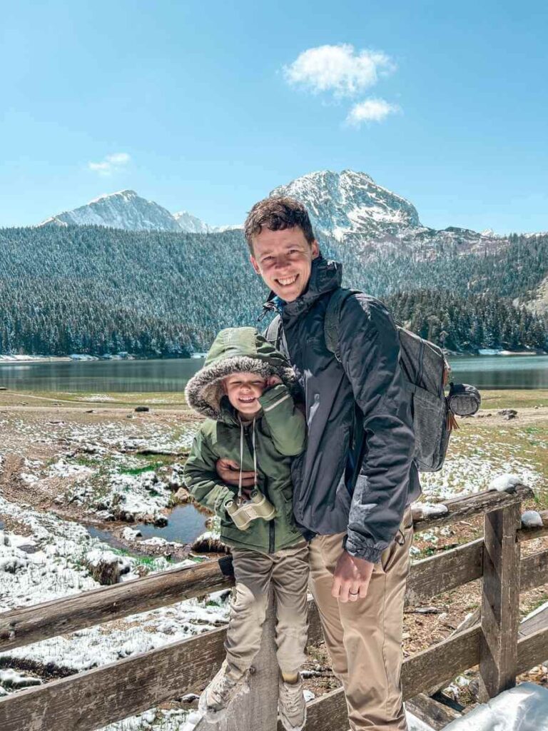 Father and son standing by Black Lake with the Durmitor mountains in the background