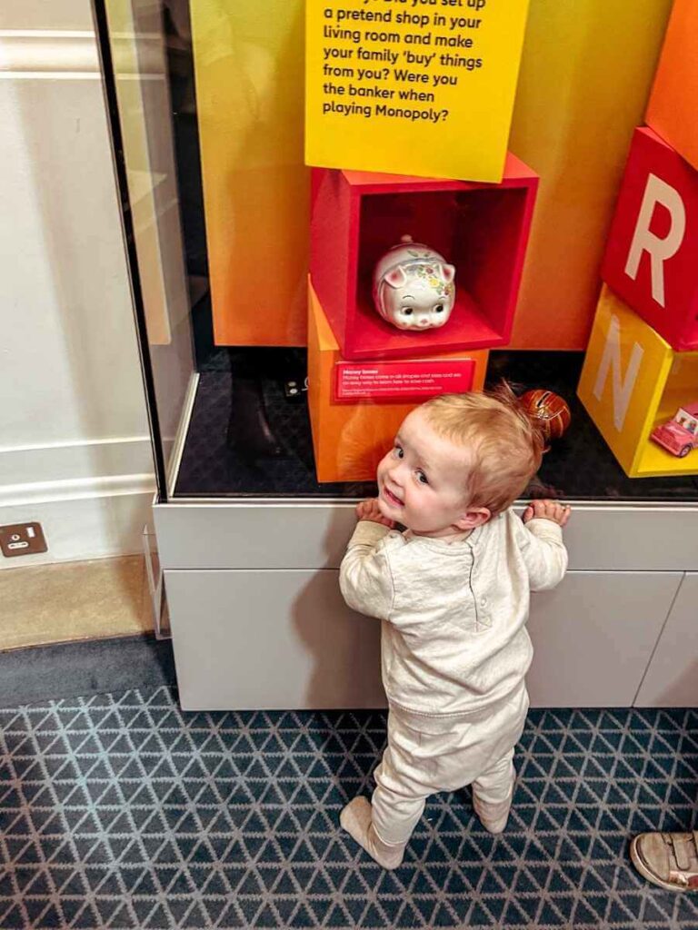 Baby observing a display case at the Bank of England Museum in London