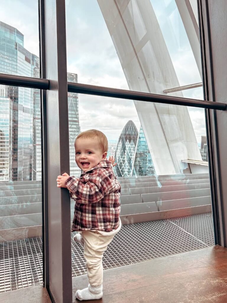 Baby at the Sky Garden with the Gherkin building visible in the London skyline
