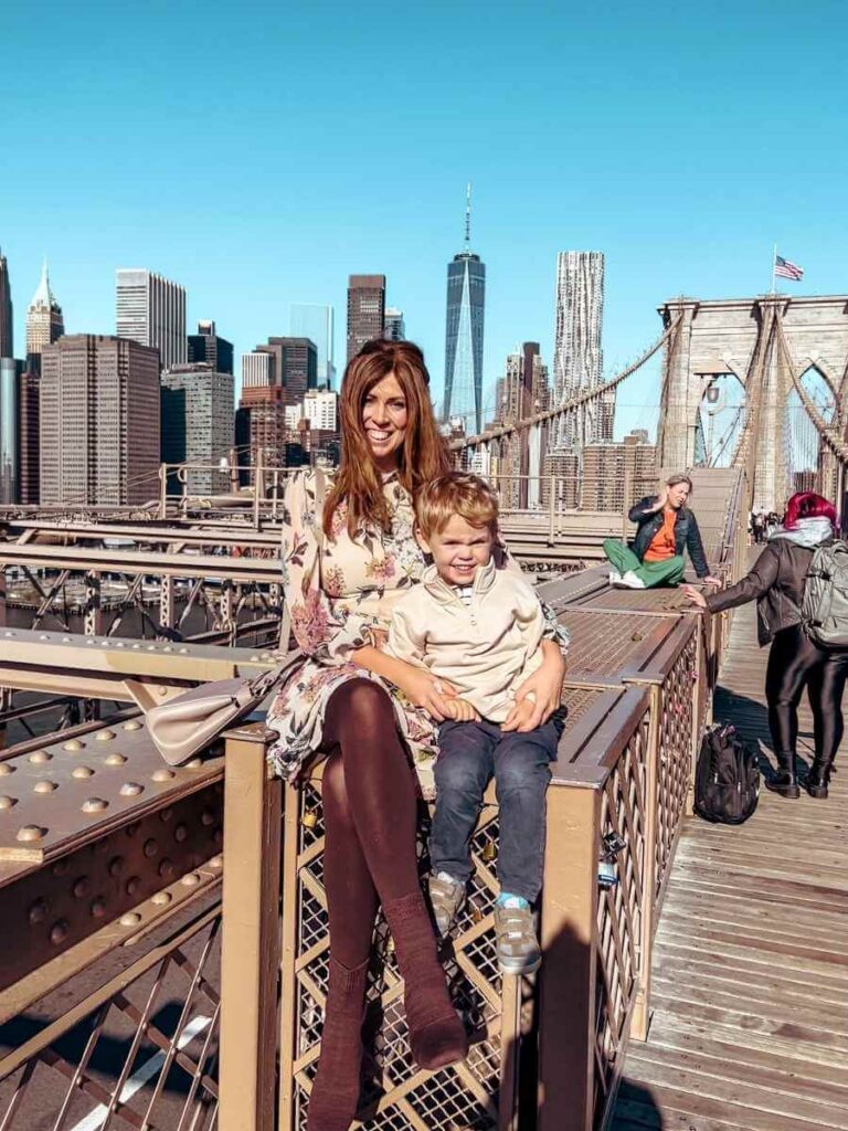 My son and I posing on the Brooklyn Bridge during our 4-day family itinerary in New York