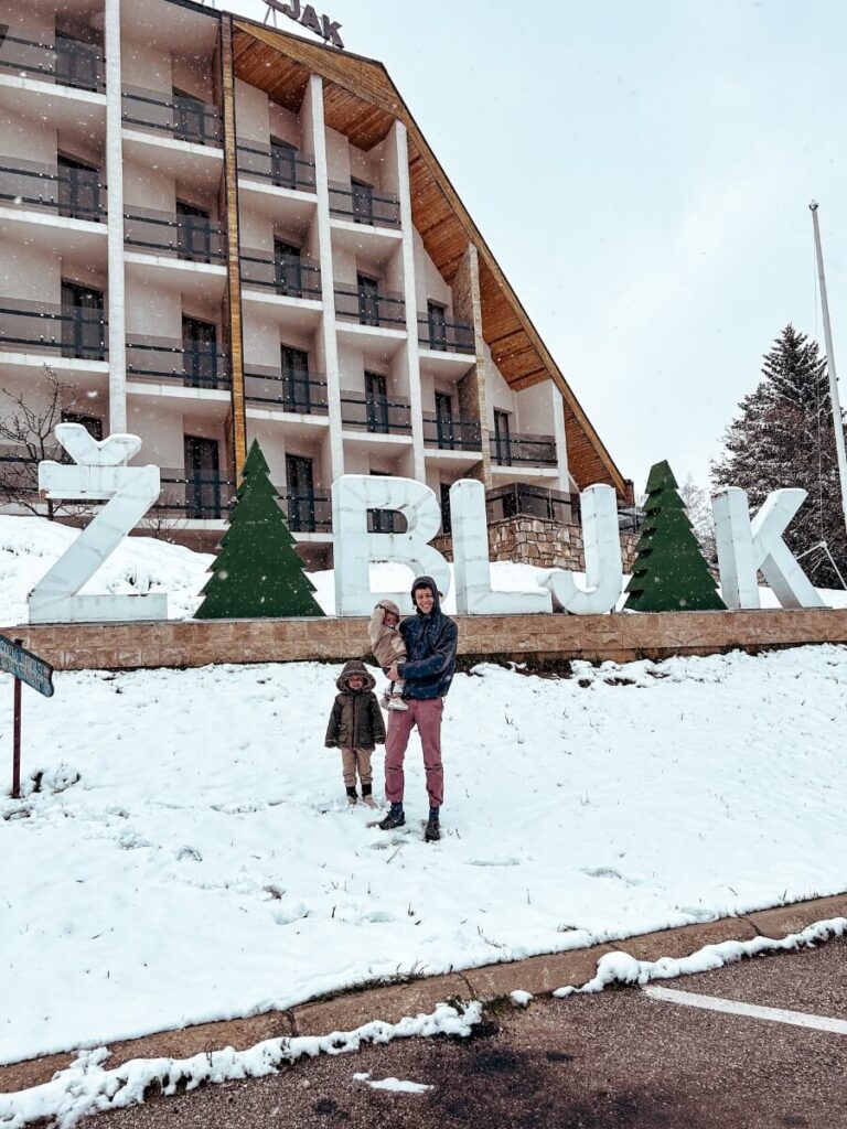 Family posing in front of the Zabljak sign surrounded by snow in Montenegro