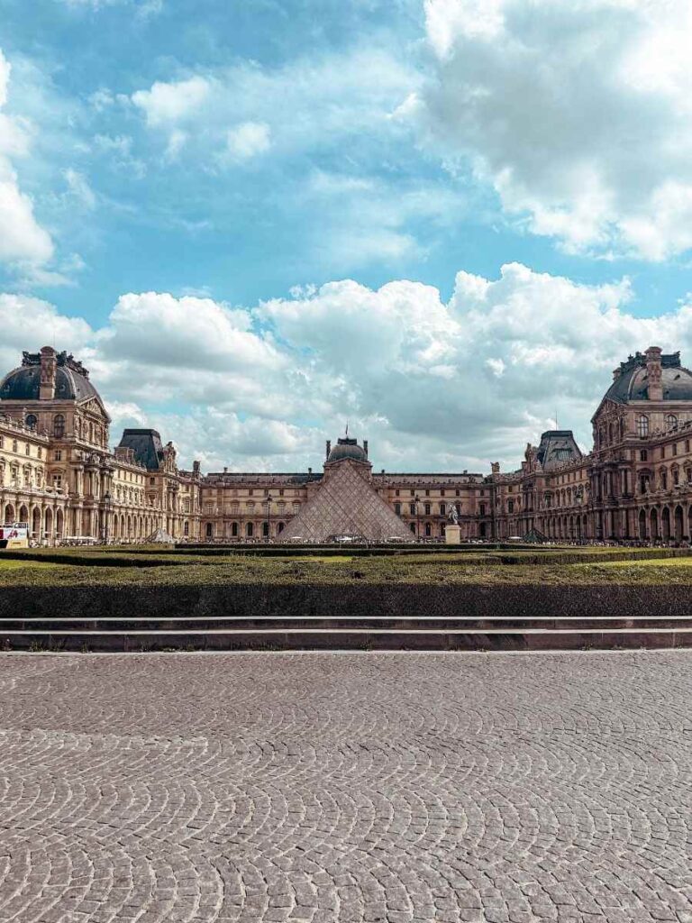 Wide view of the Louvre Museum with the glass pyramid and historic buildings