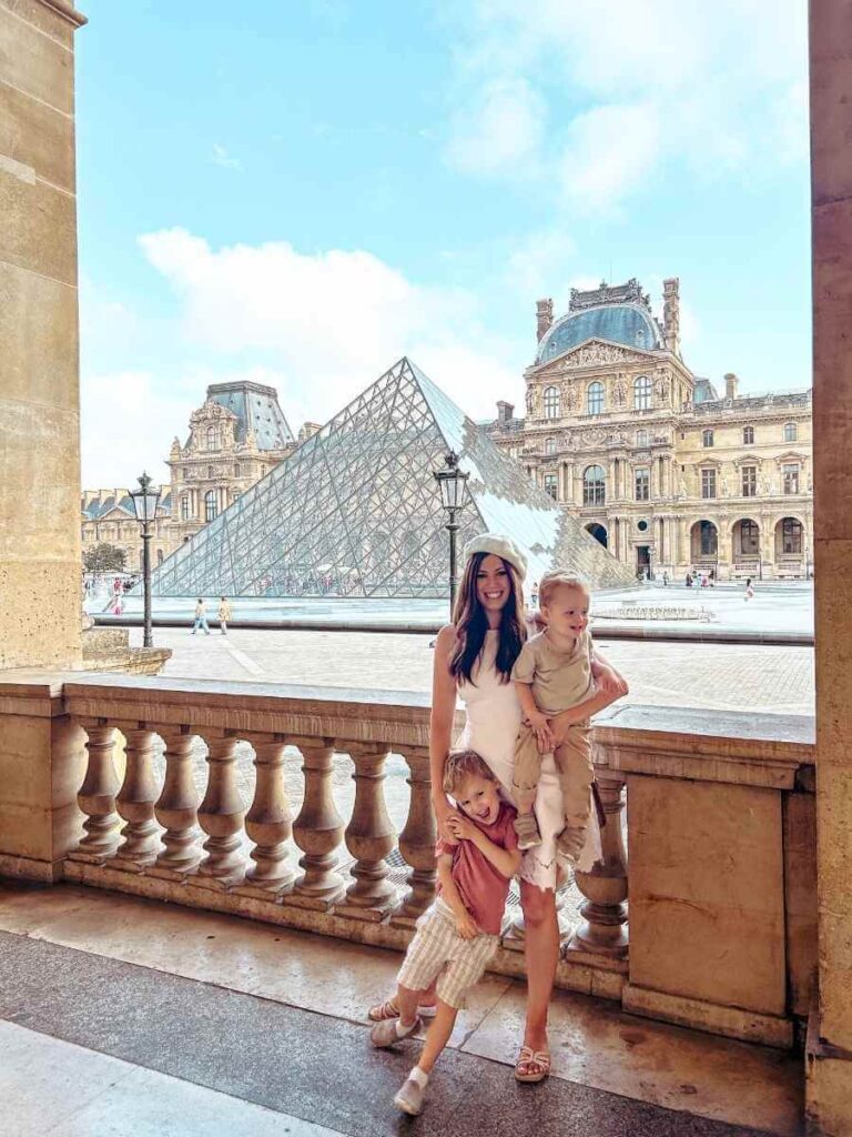 In front of the Louvre Pyramid on a sunny day on our Paris family trip