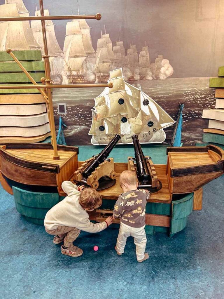 Kids exploring and playing with interactive cannons in the Ahoy! gallery at the National Maritime Museum – perfect for toddlers visiting the maritime museum.