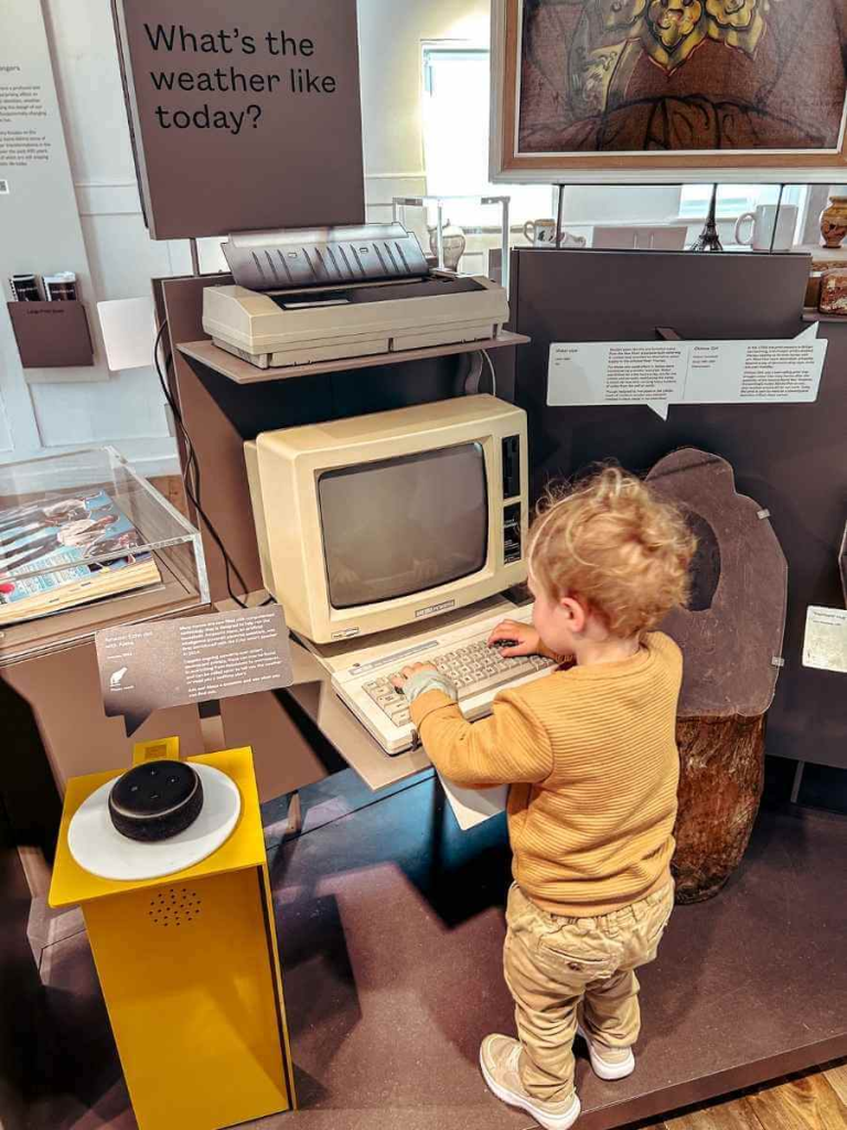 Toddler exploring a vintage computer at the Museum of the Home, London