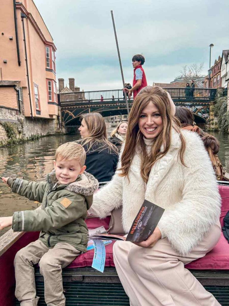 Mum in the City and her son seated together during a family punting Cambridge experience.