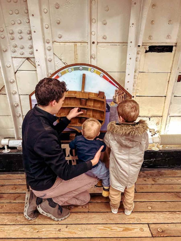 Children playing with a hands-on game aboard the Cutty Sark, perfect for young visitors.