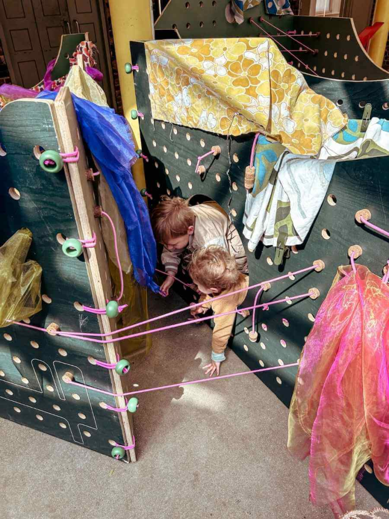 Children playing inside the wooden playhouse in the Museum of the Home.
