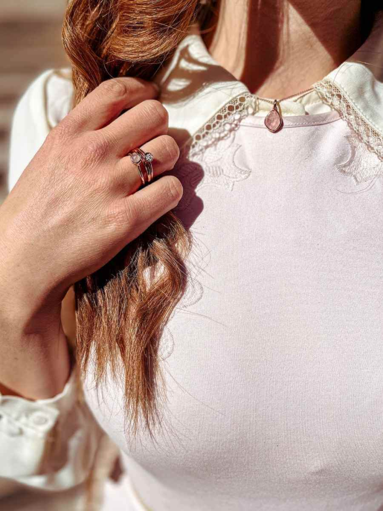 Close-up of a delicate necklace layered under a lace-edged collar — a subtle accessory choice for a classic feminine style capsule wardrobe.