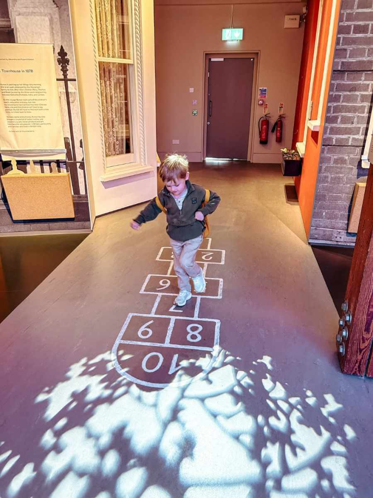 Child playing hopscotch as part of the interactive exhibits at the Museum of the Home