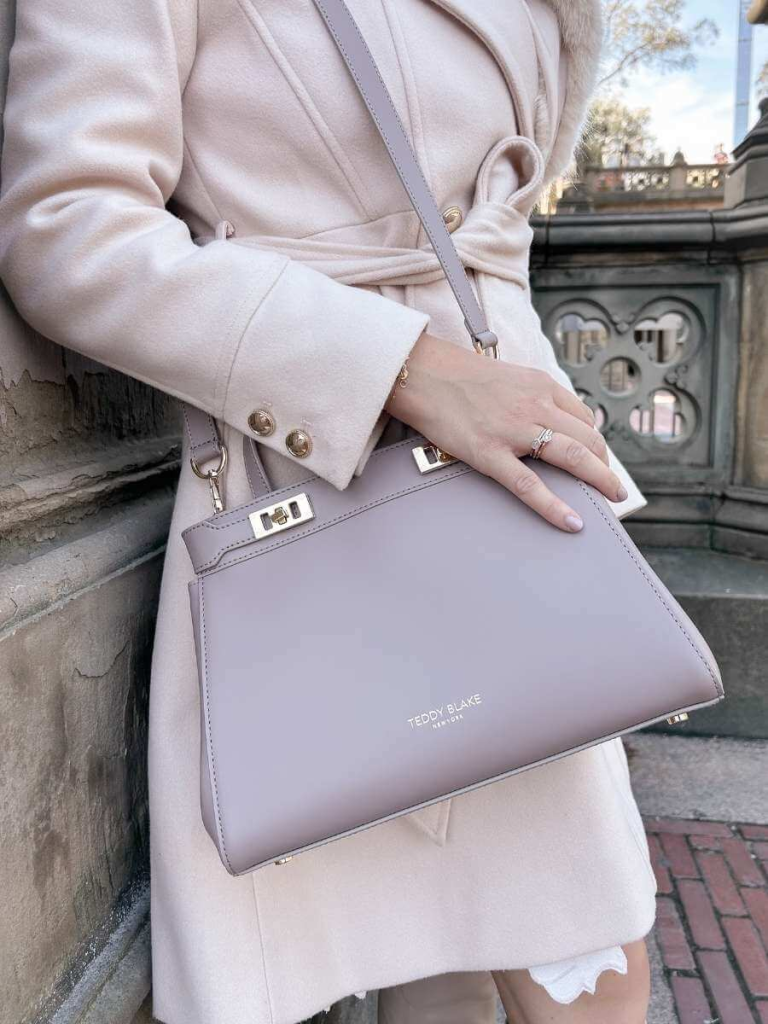 Close-up of a structured leather handbag from Teddy Blake, a timeless piece that elevates any feminine capsule wardrobe with elegance.