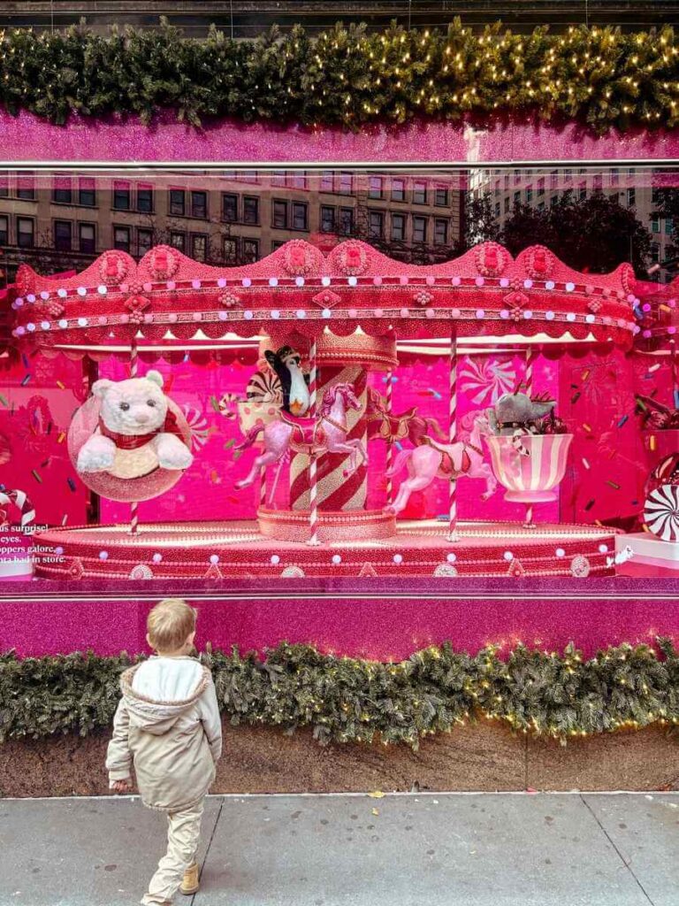 Child looking at the magical Macy’s Christmas window displays in New York at Christmas.