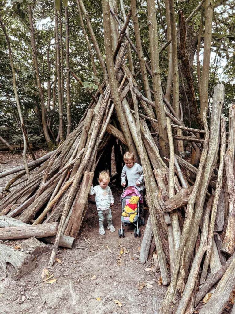 Kids playing inside a wooden log house along the Ashdown Forest Winnie the Pooh walk
