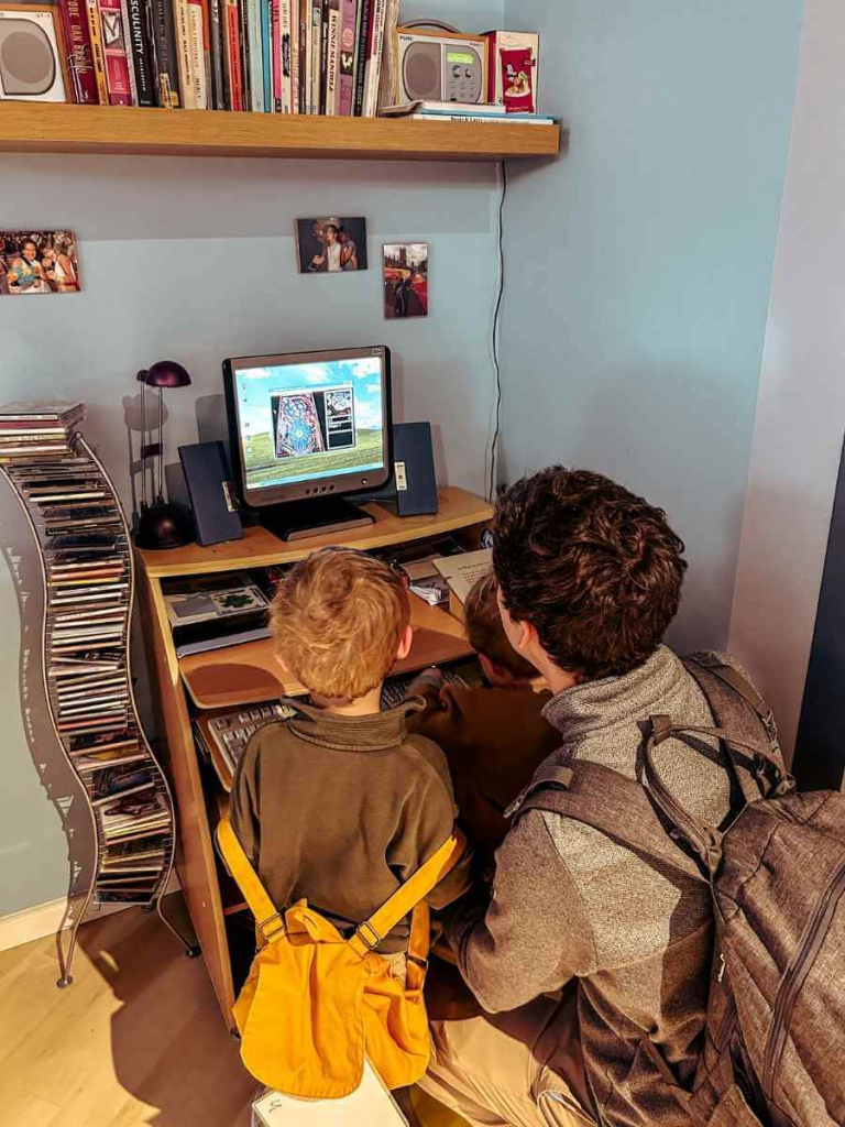 Family playing The Sims on a retro computer setup at the Museum of the Home

