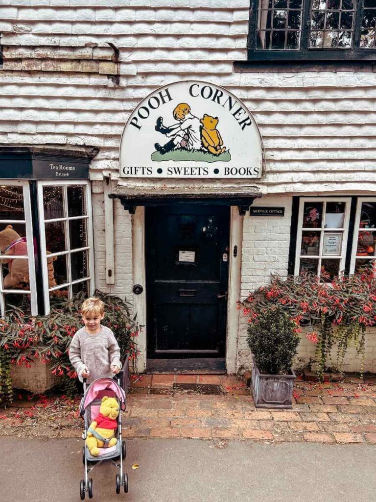 Child outside Pooh Corner shop and tearoom in Ashdown Forest Winnie the Pooh trail