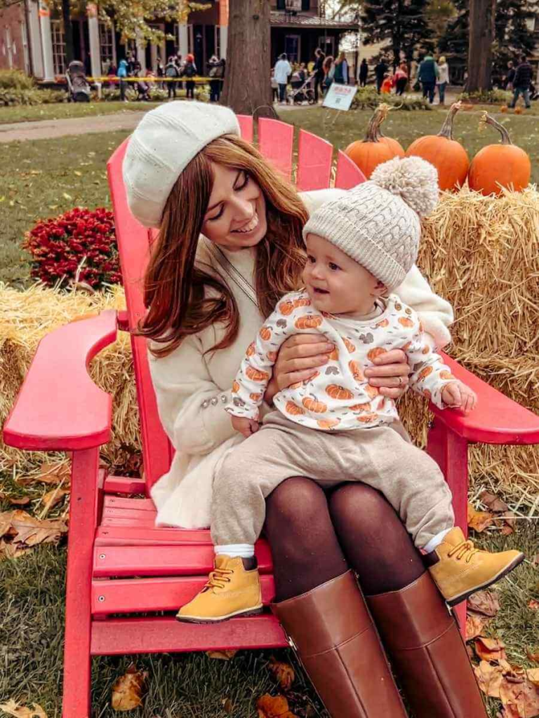 Mum in the City and  baby in a cozy fall setup with hay bales and pumpkins — capturing autumn moments in NYC this October.

