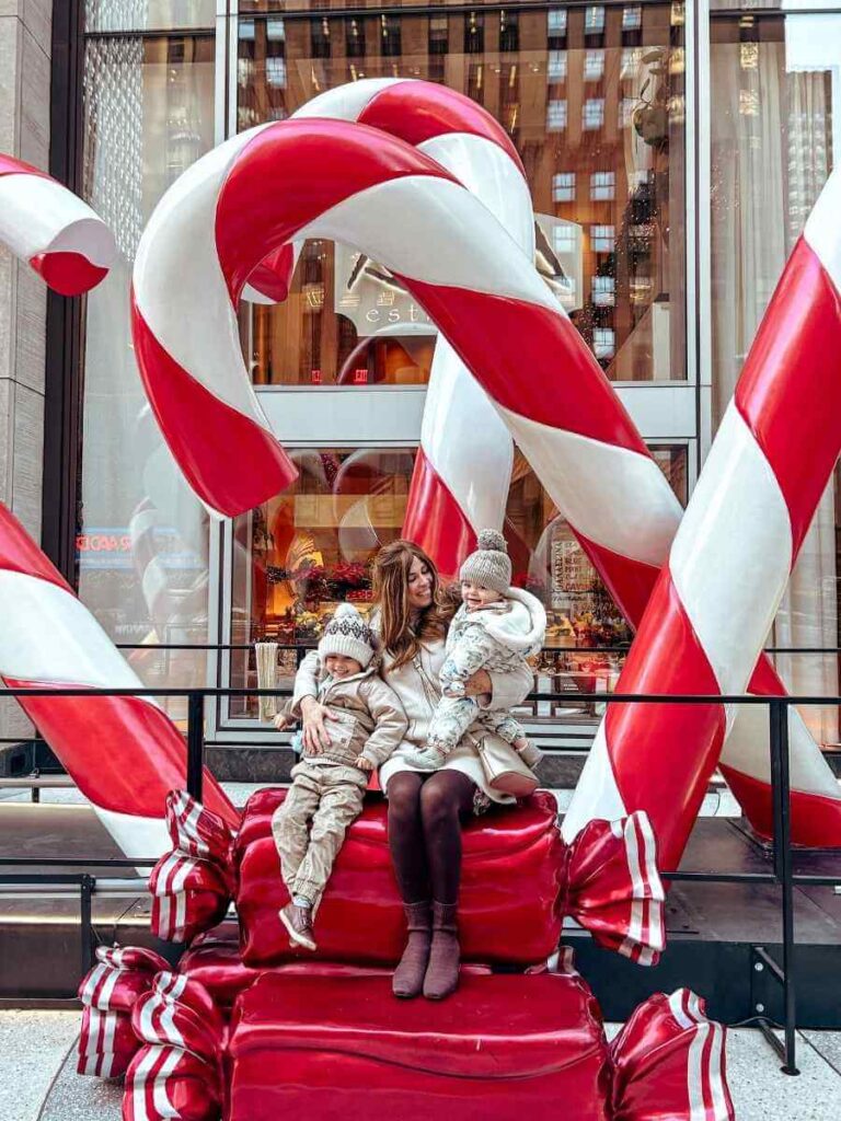 Family posing by Candy Cane decorations in Rockefeller Plaza in NYC.