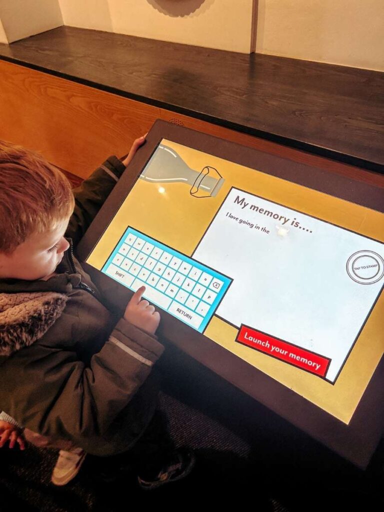 Young boy using an interactive touch screen in the Sea Things gallery at the Greenwich Maritime Museum – engaging for kids.