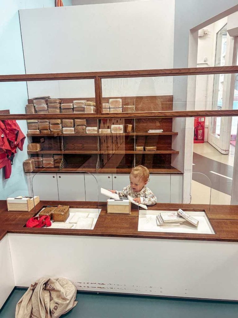 Toddler playing in the Sorted! play area’s post office at The Postal Museum.